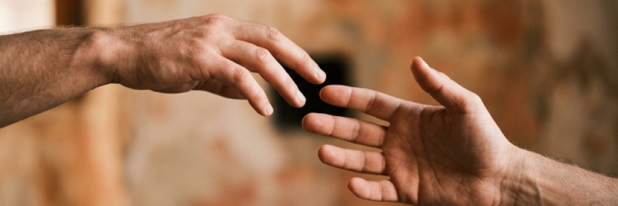 Duas mãos quase se tocando, mas sem se alcançar completamente, como se uma estivesse soltando a outra